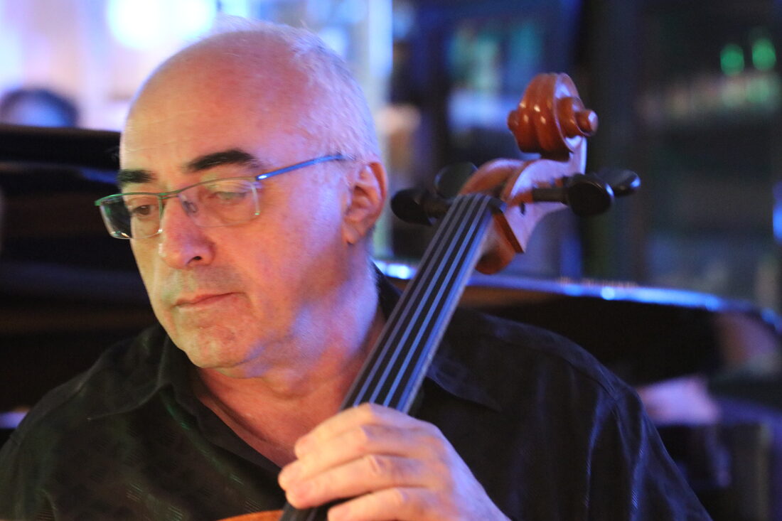 Close portrait of Alexander Kaganovsky looking down at his cello