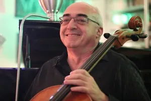 צ׳לן מחייך מחזיק את הצ׳לו שלו