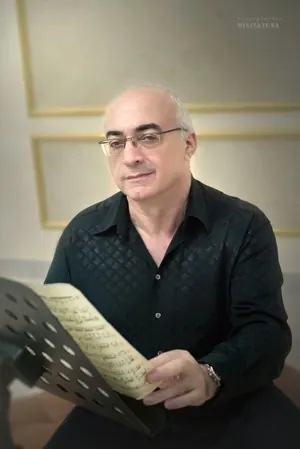 גבר במשקפיים מחזיק דפי תווים